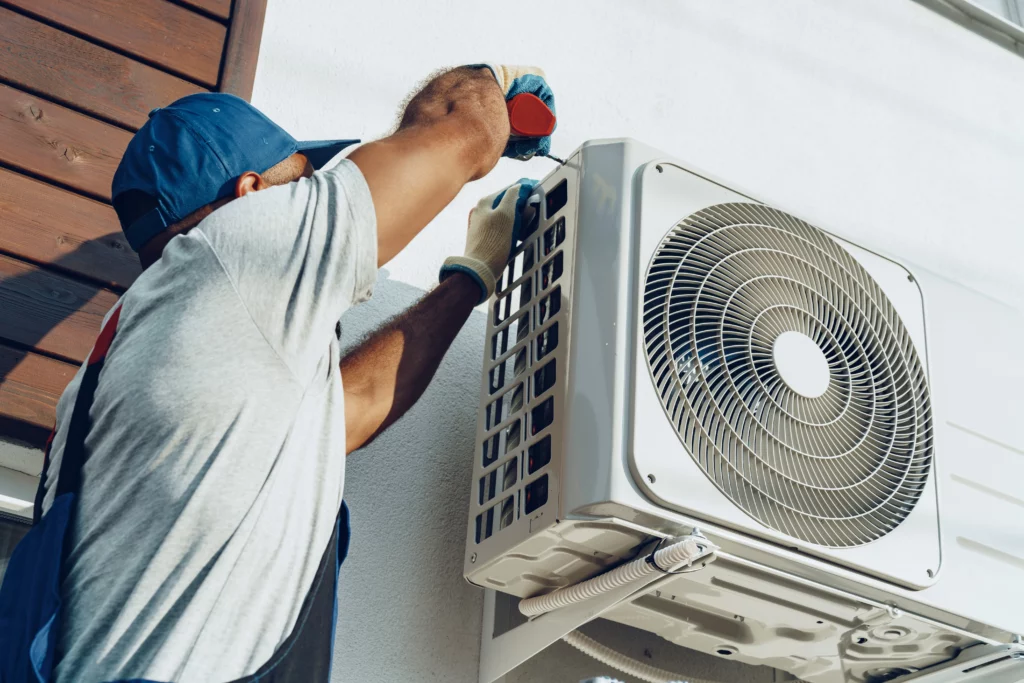 repairman installing outside air conditioning unit